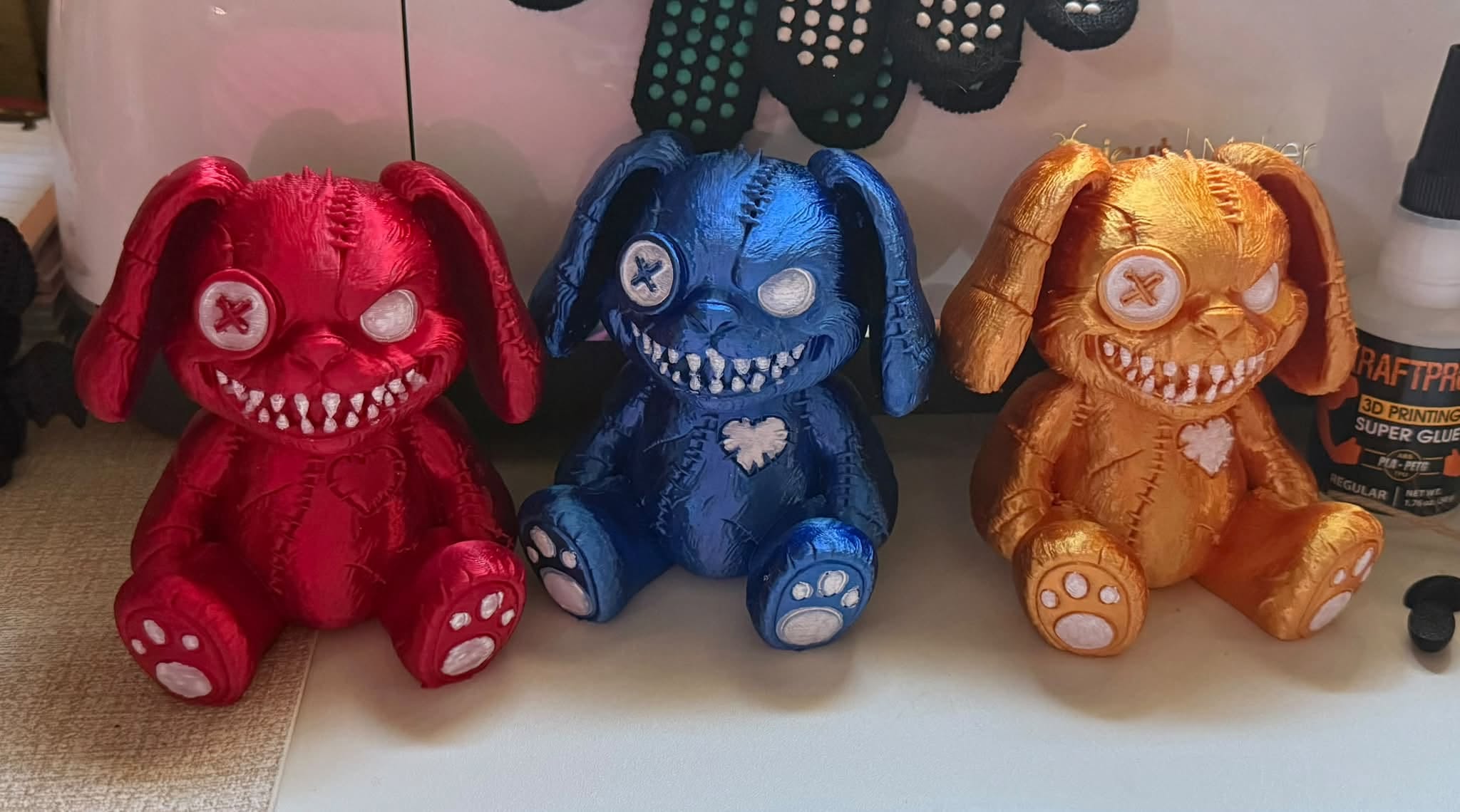 Trio of creepy-cute stitched bunny character prints in red, blue, and gold